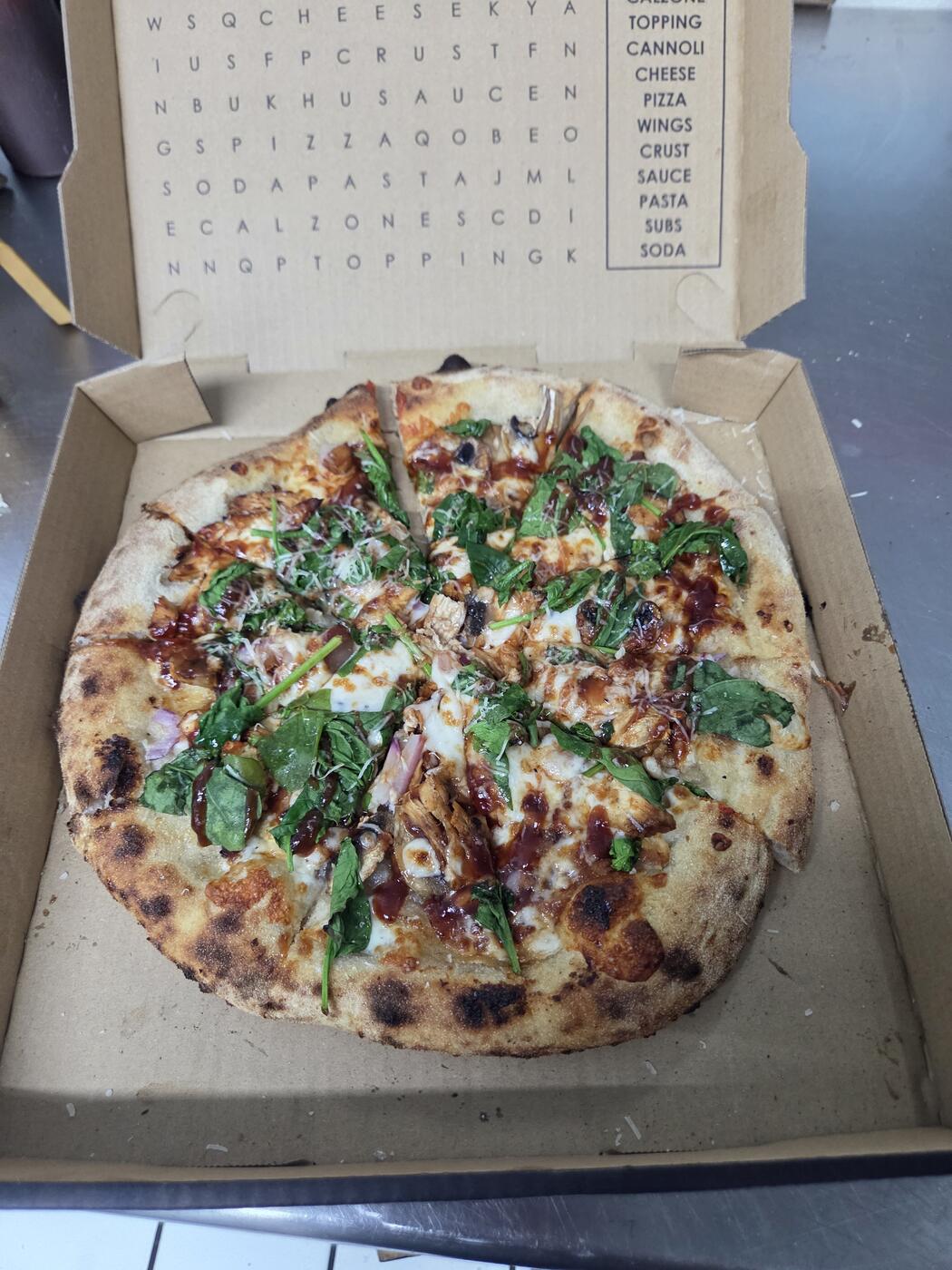 Pizza with chicken, spinach, and a red sauce