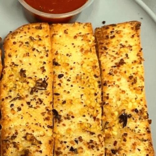Garlic bread sticks with a cup of marinara