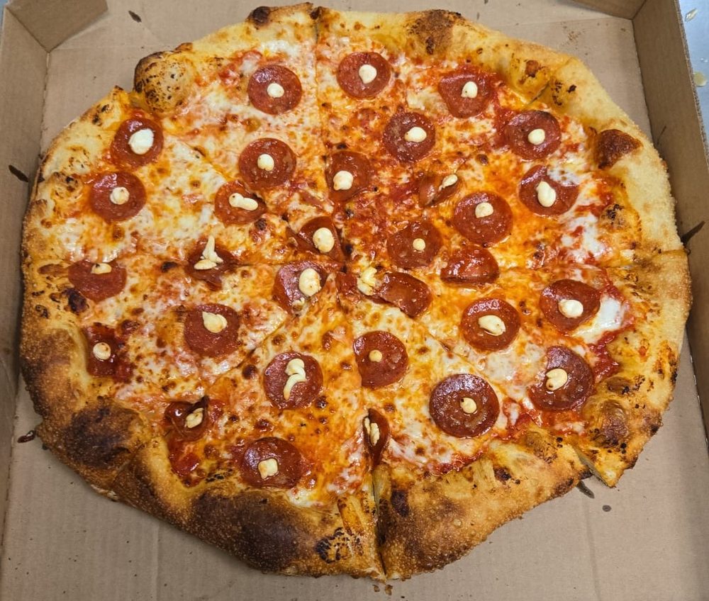 The Inferno: wood-fired cup-and-char pepperoni pizza with ricotta and hot honey, leopard-spotted crust