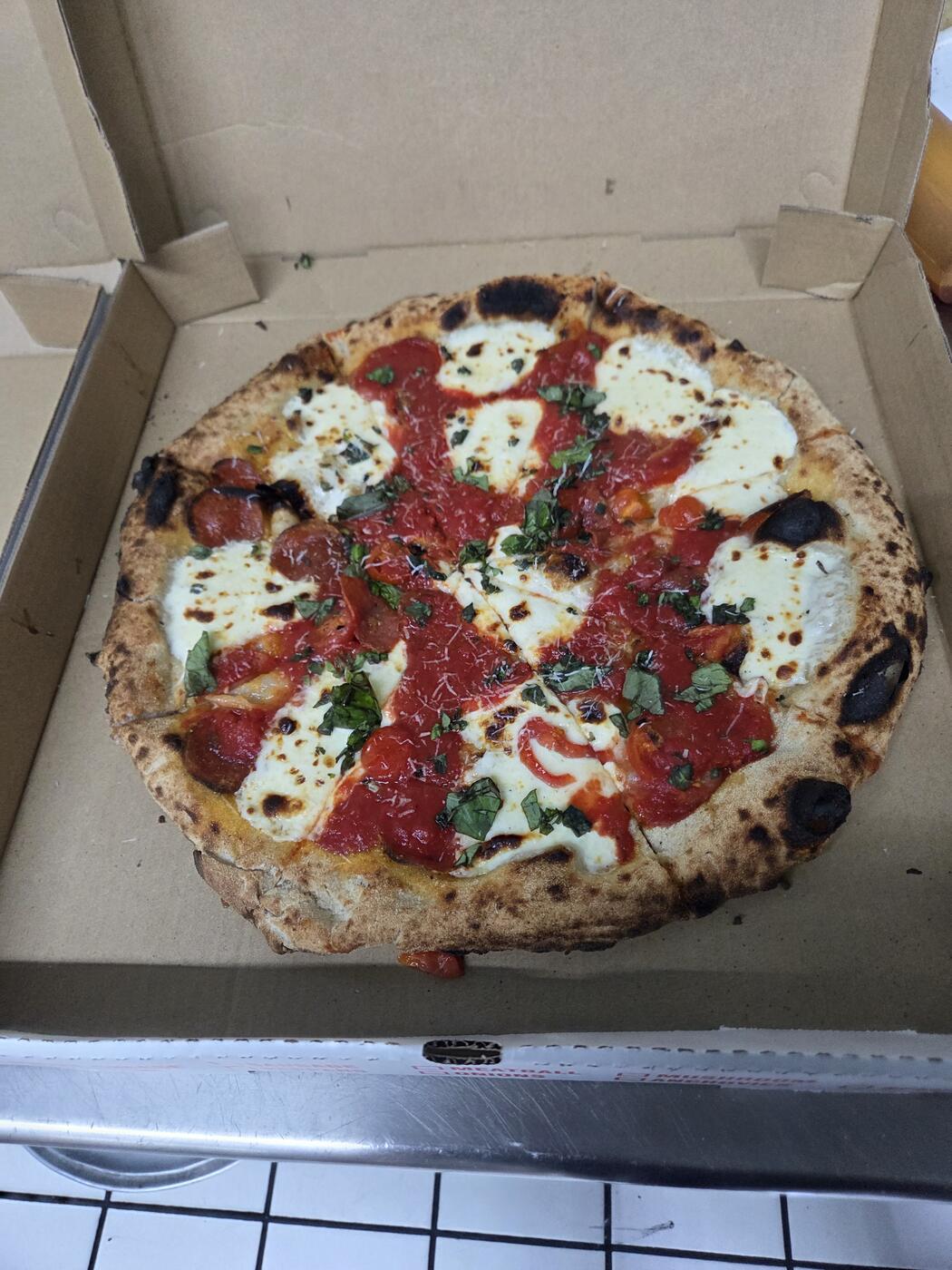 Margherita pizza with tomato, fresh mozzarella, and basil
