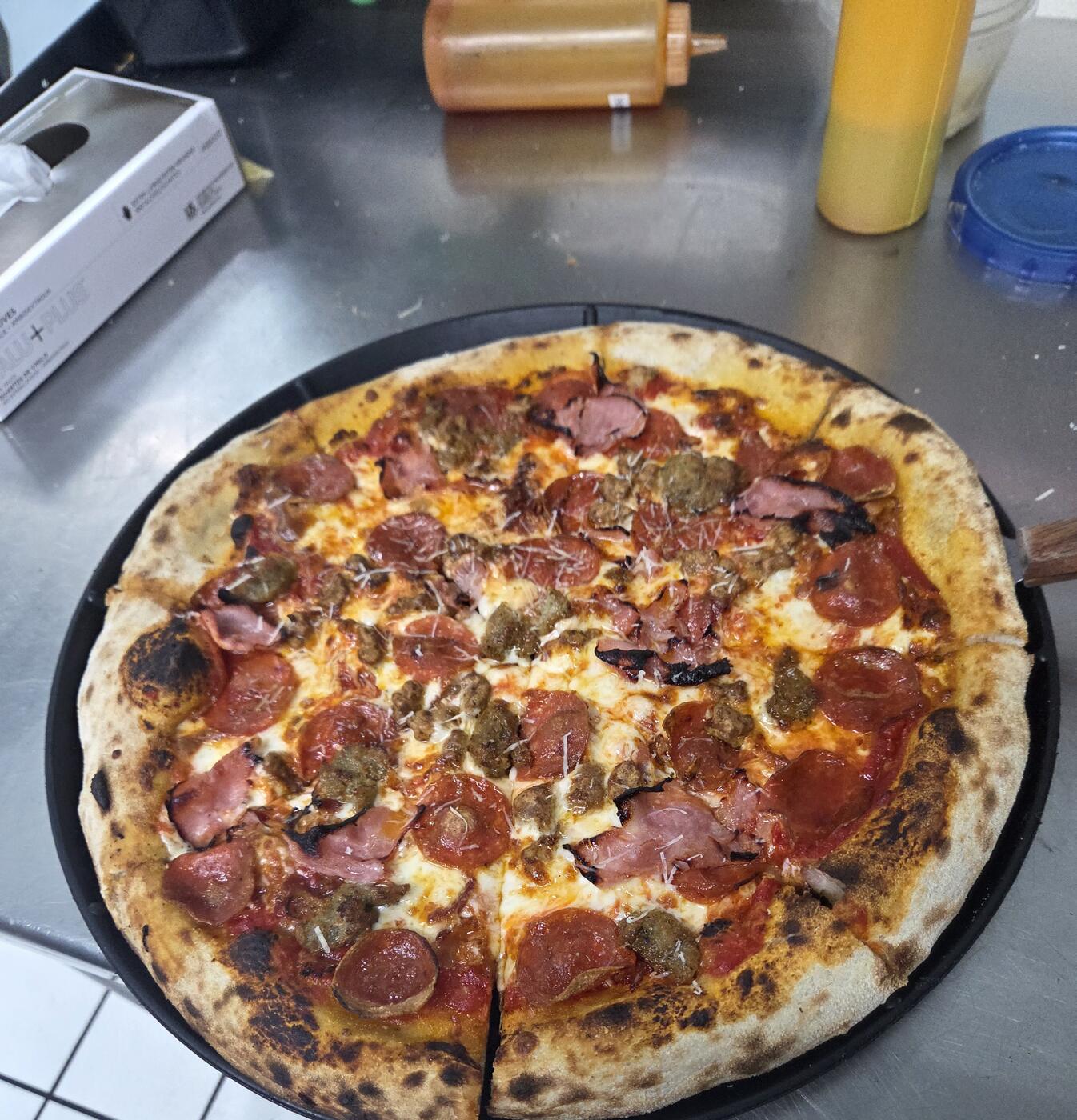 Meat lovers pizza with pepperoni, ham, and sausage